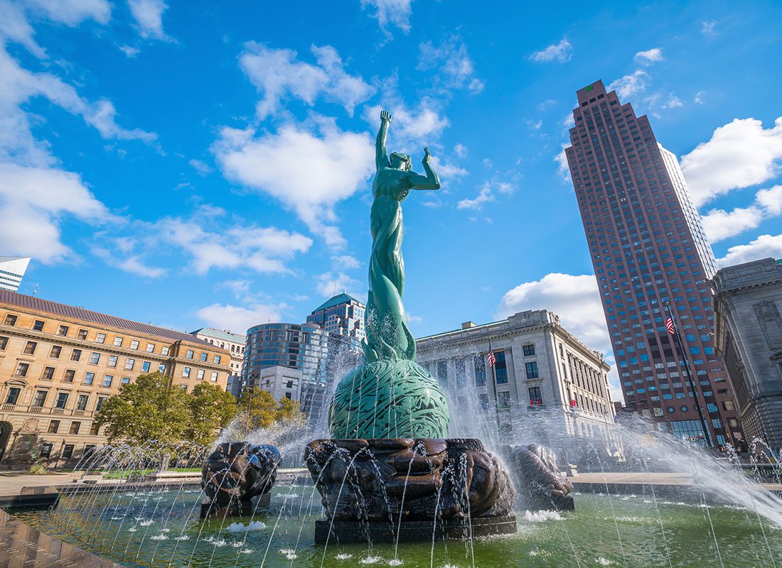 About Our Agency - View of a Statue and Water Fountain in Downtown Cleveland Ohio Surrounded by Commercial Buildings on a Sunny Day